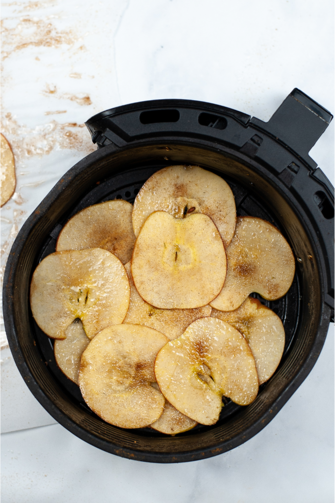 Place the seasoned apple slices in the air fryer.