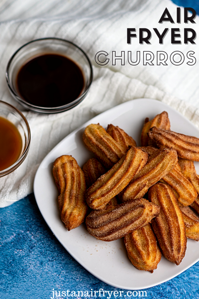 title image for air fryer churros with churros on a white plate with chocolate and caramel dipping sauces in clear bowls on a white towel