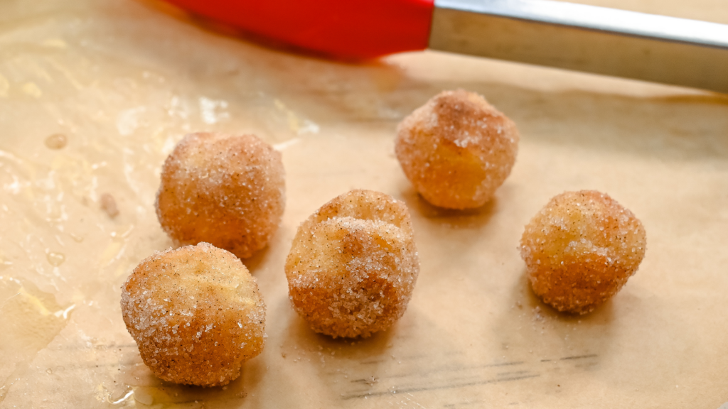 The Easiest Donuts Holes in the Air Fryer from Biscuits on brown parchment paper. 