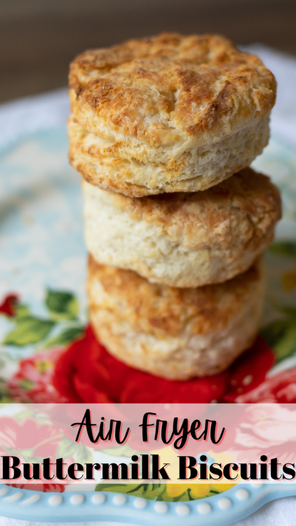 Title image for air fryer buttermilk biscuits with 3 biscuits stacked on top of each other on a red and blue floral plate. 