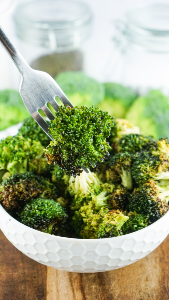 Fresh Raw Broccoli in the Air Fryer with a fork picking up a bite. 