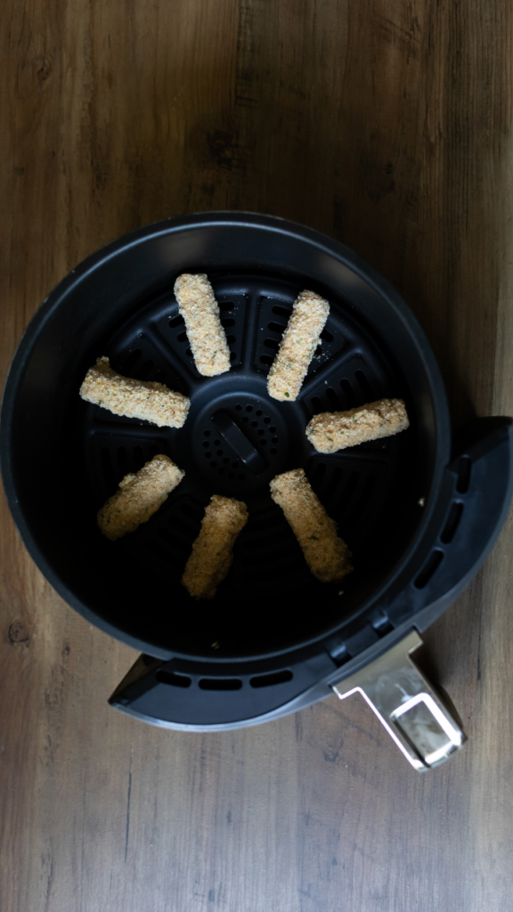 Placing the mozzarella sticks in the air fryer 