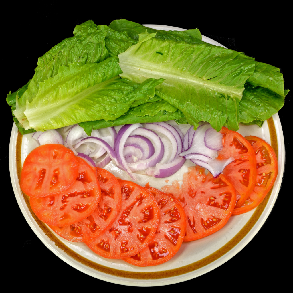 Platter full of lettuce, sliced tomato and sliced onion