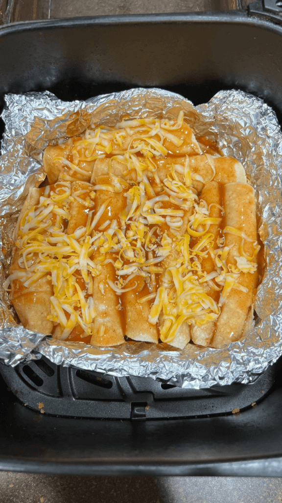 Air Fryer Cheese Enchiladas sprinkled with cheese ready to cook in the air fryer
