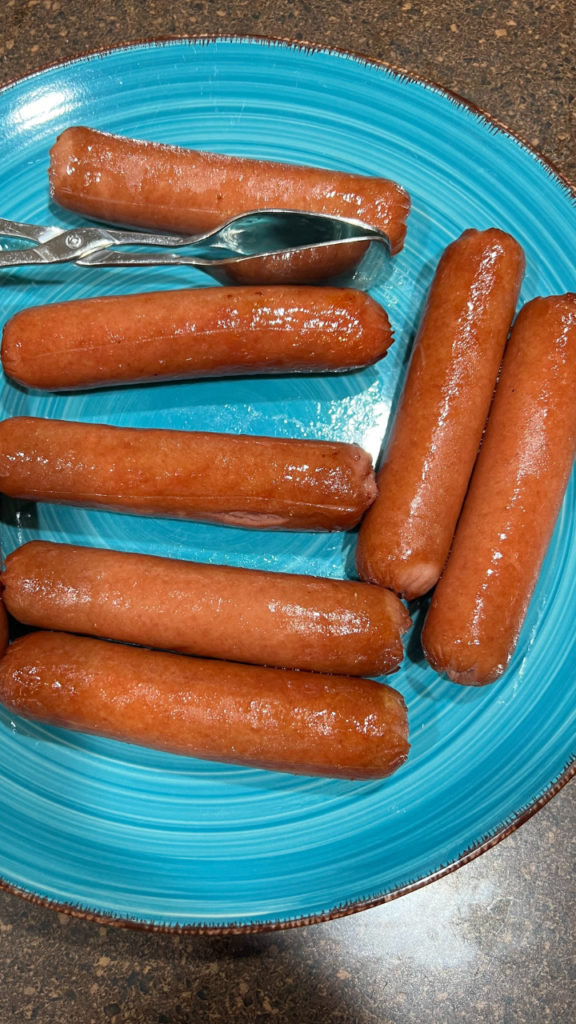 Cooked Air Fryer Hot Dogs on a turquoise plate that have plumped up nice and juicy.