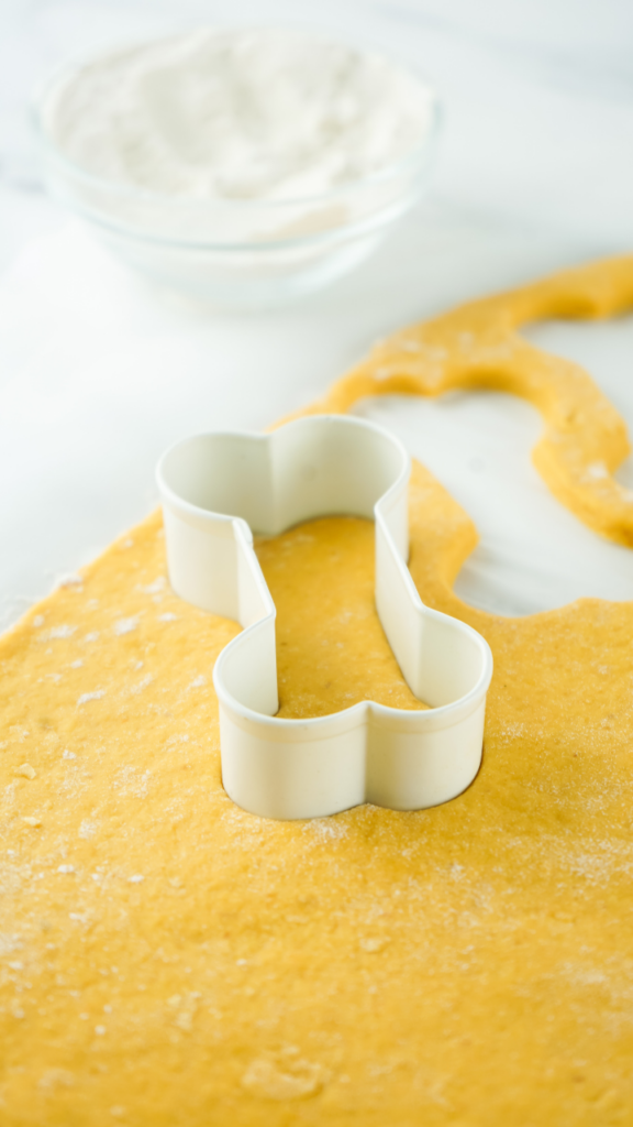 Cutting out the dog treats with a bone cookie cutter. 