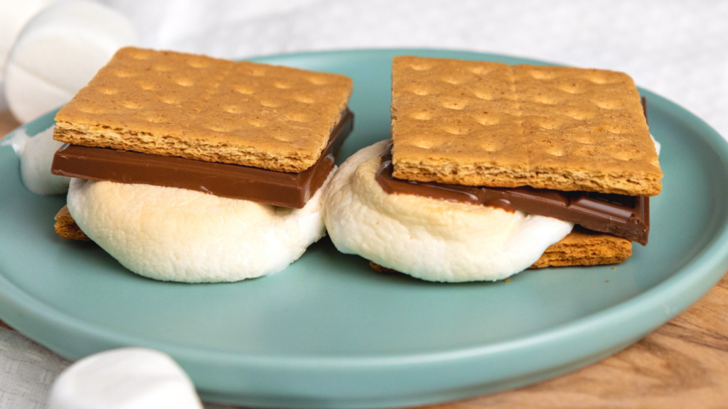 Air Fryer S'mores on a light green plate ready to eat and oozing with ooey gooey marshmallows