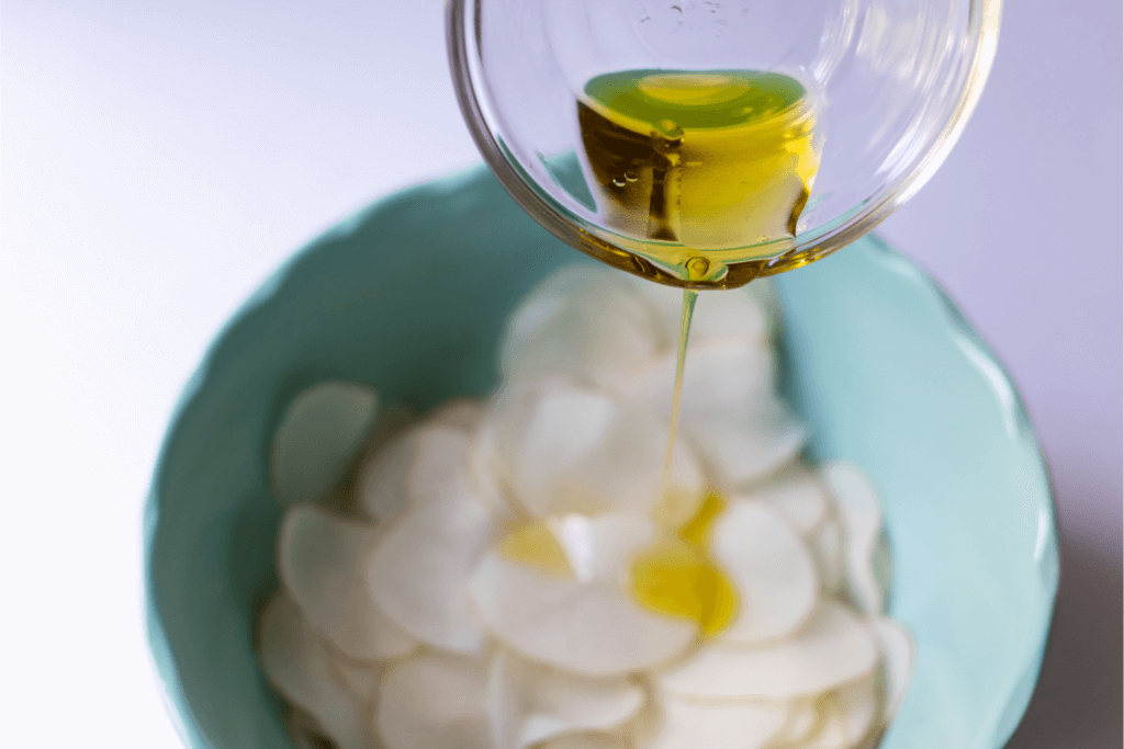Adding oil to potato slices