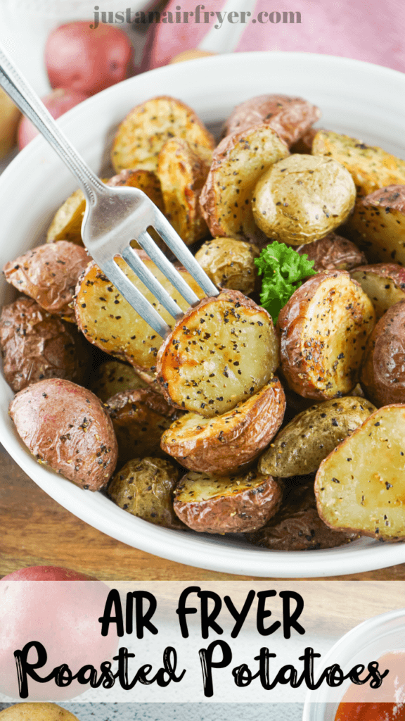 Title image with a fork piercing a single potato in a white bowl full of air fryer roasted potatoes. 
